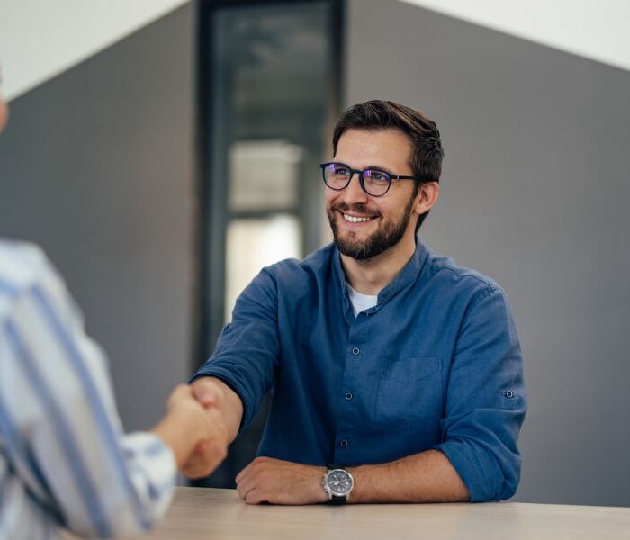 Job candidate shaking hands with a recruiter during an interview, illustrating how to find a job in Aruba