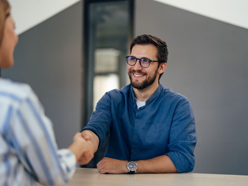 Job candidate shaking hands with a recruiter during an interview, illustrating how to find a job in Aruba